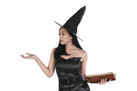 Portrait of asian witch woman with book and open palm isolated over white backgroundの写真素材