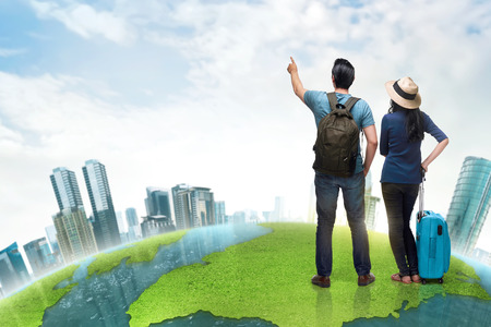 Happy asian couple tourist with suitcase and backpack against futuristic backgroundの写真素材