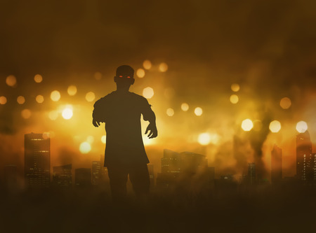 Silhouette of zombie with scary red eyes walking in the middle of smokeの写真素材