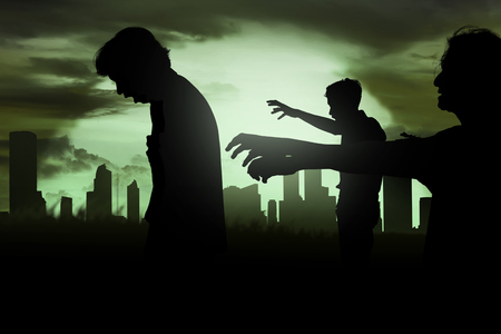 Silhoutte of zombies walking over cemetery in nightの写真素材