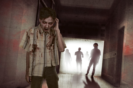 Horrible asian zombies with red eyes on the dark roomの写真素材