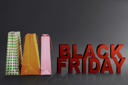 Black Friday text with colorful paper bag over black backgroundの写真素材