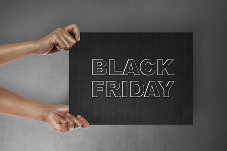 Hand holding signboard with Black Friday text. Black friday conceptの写真素材