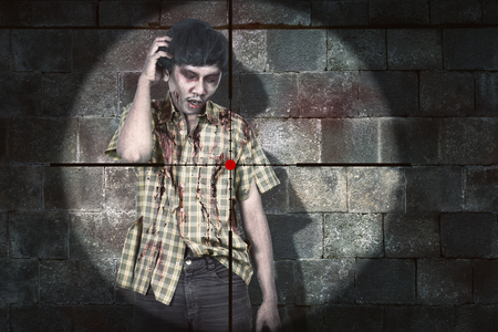 Weapon aiming to shooting bloody asian zombie man over black wall backgroundの写真素材