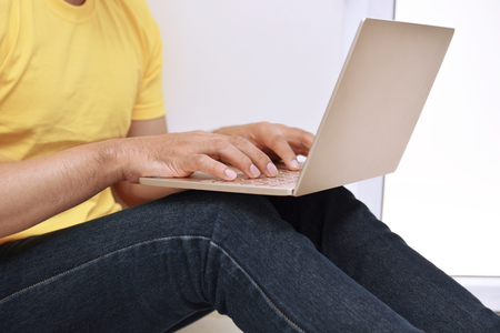 Man typing on laptop at homeの写真素材