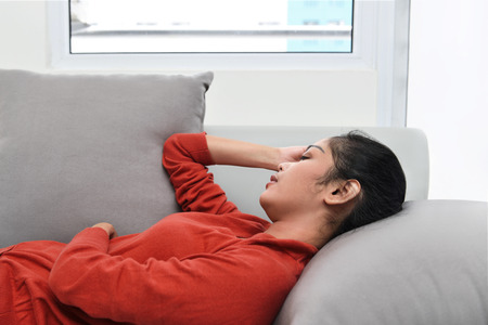 Beautiful asian woman sleeping on a couch in the living roomの写真素材