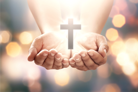 Human hand with shape cross in open palm over blur backgroundの写真素材