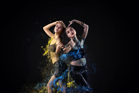 Portrait of two asian belly dancer perform with colorful paint on black backgroundの写真素材