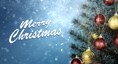 Closeup of Christmas tree decoration with colorful bauble and Merry Christmas sign on snowfall backgroundの写真素材