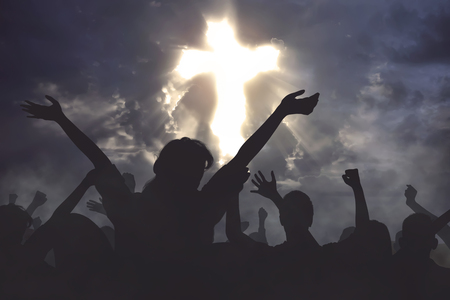 Crowd of christian people praying together to god with dramatic sky backgroundの写真素材
