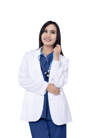 Young asian doctor with stethoscope posing isolated over white backgroundの写真素材