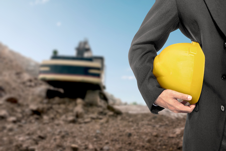 Contractor man holding a yellow helmet on construction siteの写真素材