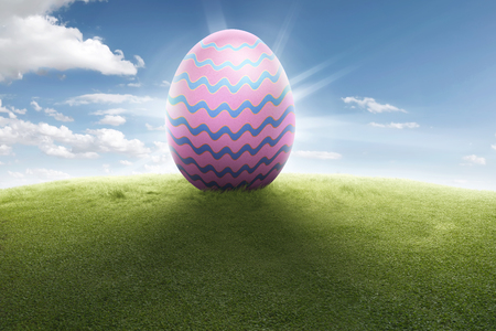Colorful easter egg on green grass with sunlight backgroundの写真素材