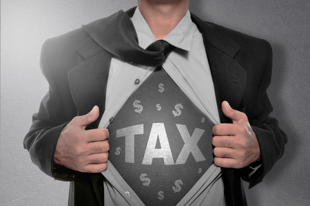 Businessman tearing off his shirt and showing Tax sign. Goods and services tax conceptの写真素材