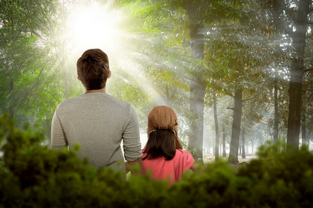 Back view of daughter and father relaxing together on the parkの写真素材