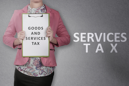 Business woman showing clipboard with Goods and services tax text. Goods and services tax conceptの写真素材