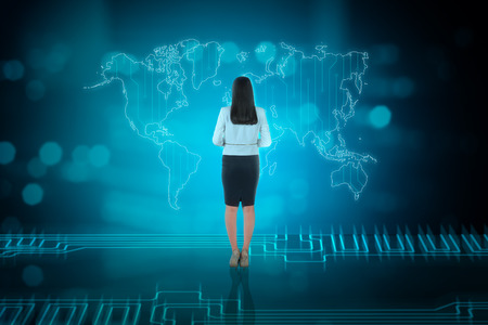 Rear view of asian business woman looking at business network on digital world mapの写真素材