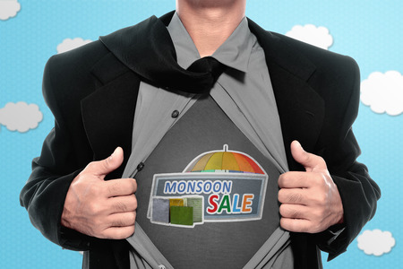Businessman tearing off his shirt and showing monsoon sale sign. Monsoon sale conceptの写真素材
