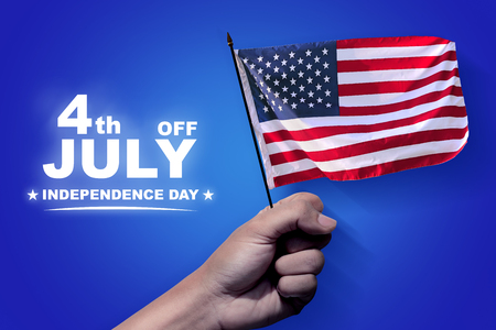 People hands holding american flag with blue background. Happy Independence Dayの写真素材