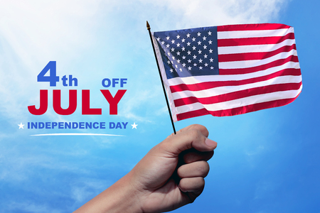 Hands with waving american flag on the sky. Happy Independence Dayの写真素材