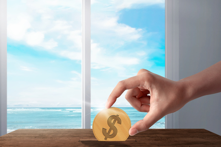 People hands put gold coin in to savings. Summer saving conceptの写真素材