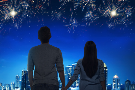 Romantic asian couple enjoying fireworks view with night scene backgroundの写真素材
