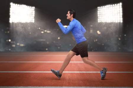 Young asian runner man running on the race track