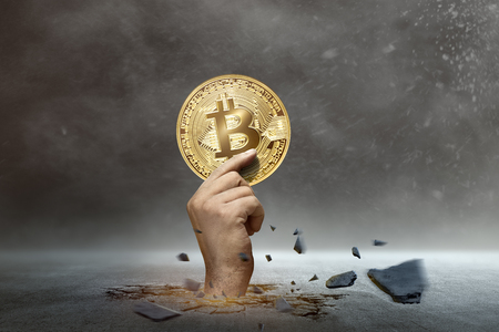 Human hands out from the ground with golden bitcoin. Cryptocurrency conceptの写真素材