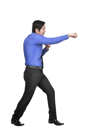 Portrait of asian businessman punching something posing isolated over white backgroundの写真素材