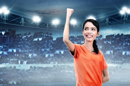Happiness asian soccer player woman after win her match on stadiumの写真素材