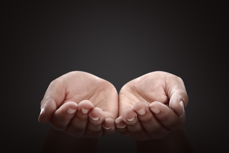 People hands with pray gesture over black backgroundの写真素材