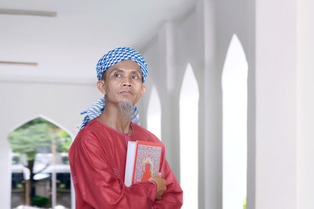 Religion asian muslim man holding the Koran inside the mosqueの写真素材