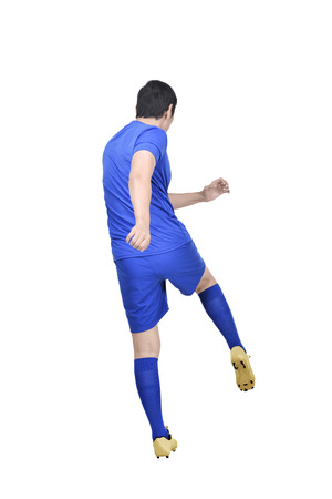 Rear view of asian footballer man shooting the ball posing isolated over white backgroundの写真素材