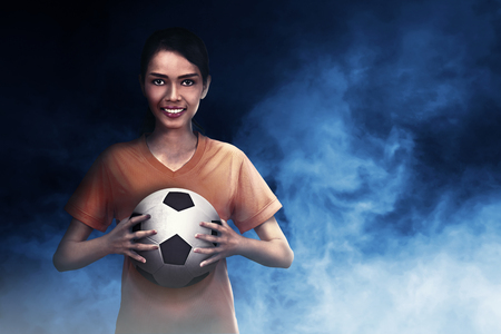 Smiling asian footballer woman carrying ball on her handの写真素材