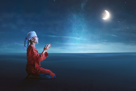 Religious asian muslim man pray to god with night scene backgroundの写真素材