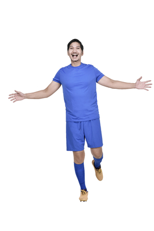Images of asian male soccer player doing sliding tackle isolated over white backgroundの写真素材