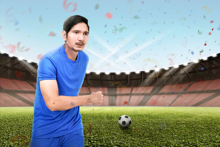 Young asian football player man playing the ball on the fieldの写真素材