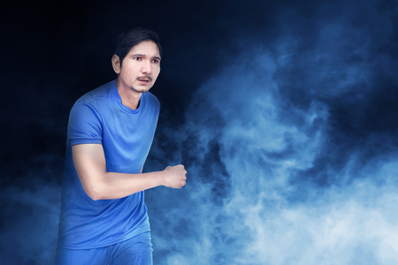 Handsome asian soccer player man with blue jersey over abstract backgroundの写真素材