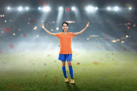 Happy asian female soccer player celebrate on the fieldの写真素材