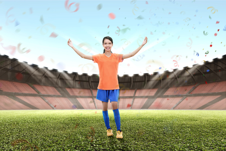 Smiling asian footballer woman celebrate victory on stadiumの写真素材