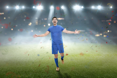 Happy asian soccer player after winning the match on the fieldの写真素材