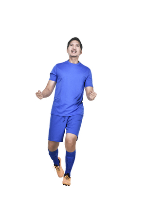 Images of excited asian football player isolated over white backgroundの写真素材