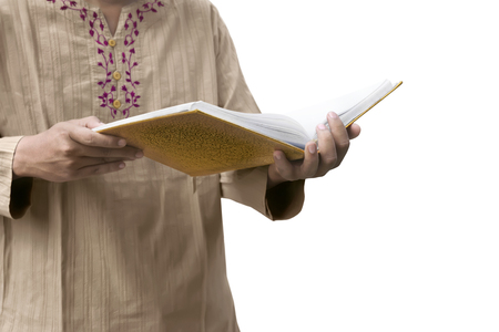 Muslim man reading the Koran isolated over white backgroundの写真素材