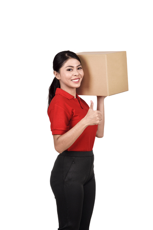 Professional asian delivery woman bring the cardboard box standing isolated over white backgroundの写真素材