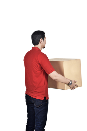 Back view of asian courier man with cardboard boxes standing isolated over white backgroundの写真素材