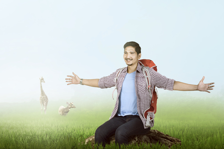Happy asian traveler enjoying the scene with green grass backgroundの写真素材