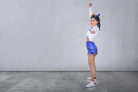 Smiling asian cheerleader in white and blue suit at indoorの写真素材