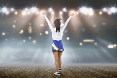 Rear view of asian cheerleader in white and blue suit on the stageの写真素材