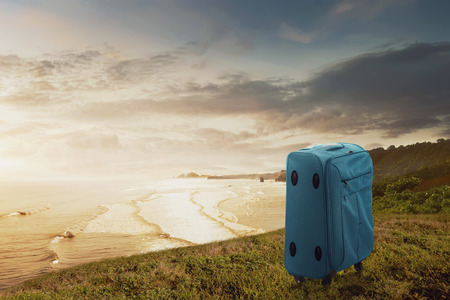 Blue suitcase on the cliff with seascapes view. Summer travel conceptの写真素材
