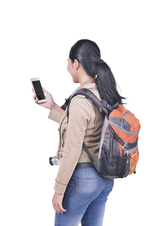 Portrait of asian traveler woman with backpack holding cell phone posing isolated over white backgroundの写真素材